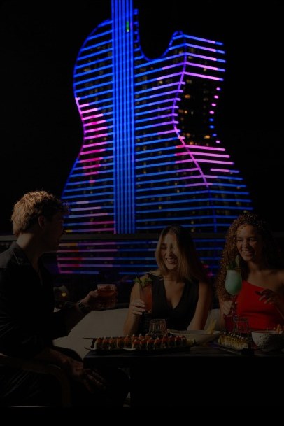 Guests at the G7 Rooftop above Hollywood's illuminated Guitar Hotel