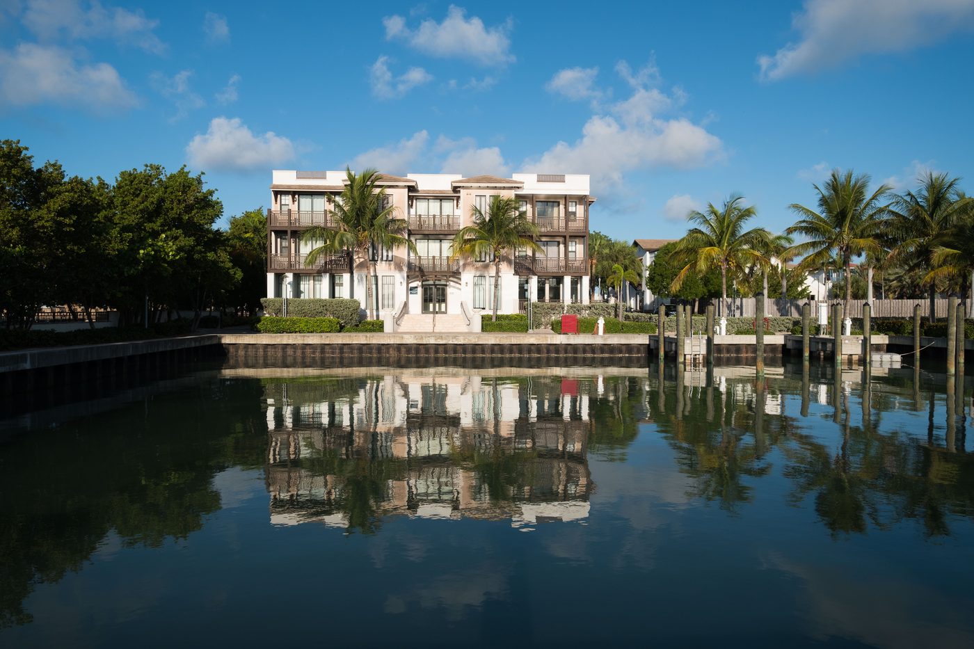 A detached three-story waterfront residence reflected in the marina at Marlin Bay